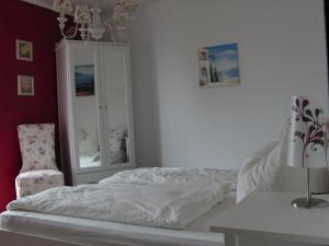 ein Schlafzimmer mit einem Bett, einem Stuhl und einem Spiegel in der Unterkunft Ferienhaus Belle - FEWO Rose in Daschow