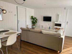 Joli T2 3* 40 m2 avec parking et terrasse في إيكس لي بان: غرفة معيشة مع أريكة وطاولة