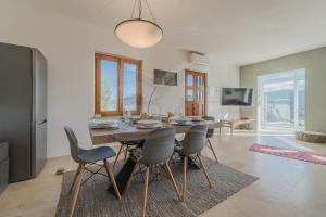 Villa la Collina Charme e Natura - Goelba في Marmi: غرفة طعام بها طاولة وكراسي