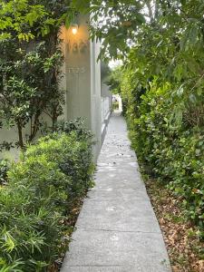 a sidewalk in front of a building with bushes at The West Gem in Miami Beach