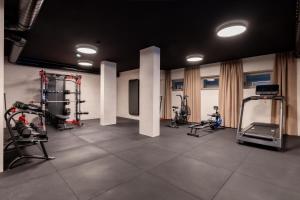 a gym with several treadmills and elliptical machines at Domenigs Luxury Apartments in Fiss