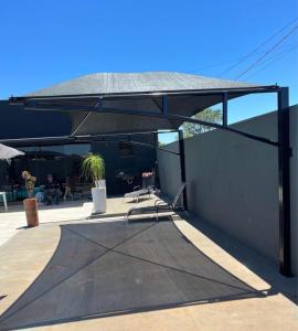a patio with a black canopy and a skateboard ramp at JOTA Área de Lazer in Dourados