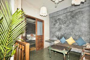 een woonkamer met een bank en een tafel bij GERANIUM HAVEN in Arambol