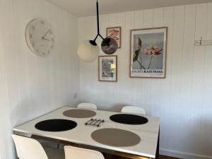 a kitchen with a table with chairs and a clock at Joli T2 3* 40 m2 avec parking et terrasse in Aix-les-Bains