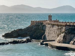 皮昂比諾的住宿－Bilocale vista mare al Castello，海边悬崖上的灯塔