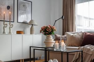 ein Wohnzimmer mit einem Sofa und einem Tisch mit Blumen darauf in der Unterkunft Simple studio in trendy Södermalm - construction work in Stockholm