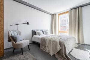 um quarto com uma cama, uma cadeira e uma janela em Comfy Studio easy to commute em Estocolmo