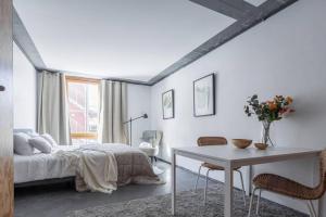 a bedroom with a bed and a table and chairs at Comfy Studio easy to commute in Stockholm