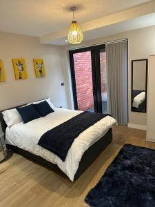 a bedroom with a large bed with a black blanket at Richardson Deluxe Apartments - 3 Bed in London