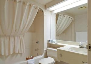 une salle de bain avec un lavabo, des toilettes et un miroir dans l'établissement Comfort Inn, à Trois-Rivières 19 autres photos