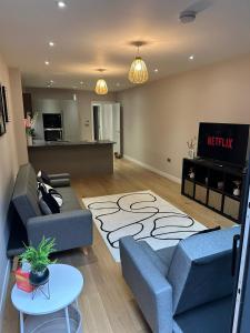 sala de estar con 2 sofás azules y cocina en Richardson Deluxe Apartments - 3 Bed, en Londres