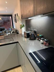 a kitchen with a counter top with a tea kettle on it at Richardson Deluxe Apartments - 3 Bed in London