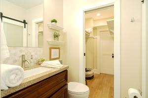 een badkamer met een wastafel, een toilet en een spiegel bij The Heron On Ivy in San Diego