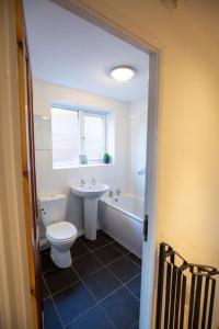 Entire 1 Bedroom House in Manchester في مانشستر: حمام مع مرحاض وحوض استحمام ومغسلة