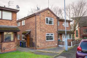 a brick house with a car parked in front of it at Entire 1 Bedroom House in Manchester in Manchester