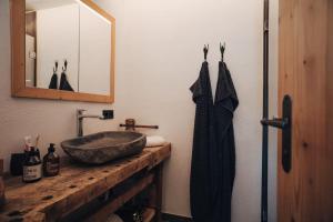 y baño con lavabo de piedra y espejo. en L.A. MOUNTAIN LODGE, en Lofer