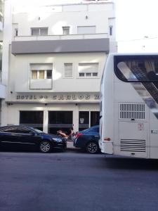 two cars parked in front of a building with a bus at Carlos VII in Mar del Plata