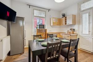 een keuken met een tafel en stoelen en een keuken met een koelkast bij home2stay worker Apartments Metzingen in Metzingen
