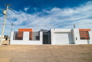 een wit gebouw met bruine luiken erop bij VILLA COSTA FELIX 1 in Puerto Peñasco