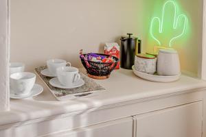 a white counter with cups and saucers on it at The Covent Courtyard Flat in London