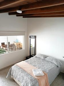 a bedroom with a bed and a large window at Espacio seguro, amplio y acogedor in Medellín