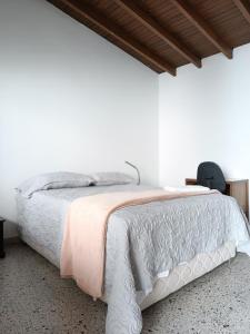 a white bedroom with a bed with a white comforter at Espacio seguro, amplio y acogedor in Medellín