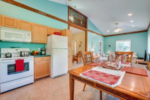 a kitchen and dining room with a table and refrigerator at Peaceful Naalehu Paradise 5 Mi to Beach! in Naalehu