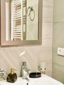 a bathroom with a sink with a mirror and a mirror at Memories House in Bakuriani