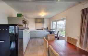 a kitchen with a wooden table and a dining room at La Cabane Penthouse in Nieuwvliet-Bad