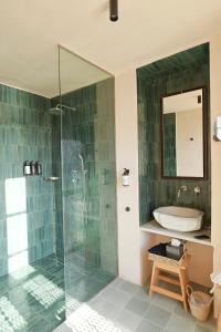 a bathroom with a glass shower and a sink at Casa Mediterraneo Hotel in Meyisti