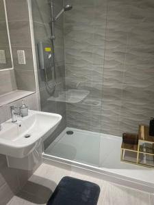 Stylish flat in Old Trafford في مانشستر: حمام مع دش ومغسلة ومرحاض