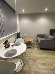 a living room with a couch and a table and chairs at Stylish flat in Old Trafford in Manchester