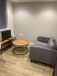 a living room with a bed and a table at Stylish flat in Old Trafford in Manchester