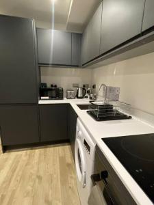 a kitchen with a stove and a washing machine at Stylish flat in Old Trafford in Manchester