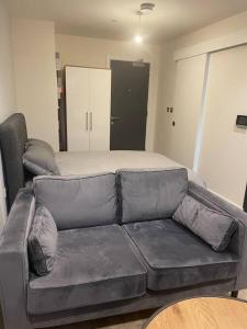 a leather couch in a living room with a bed at Stylish flat in Old Trafford in Manchester