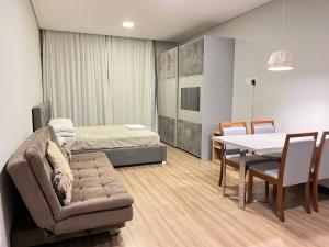 um quarto com uma cama, um sofá e uma mesa em Studio em Florianópolis