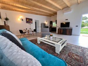 Carvoeiro B&B and SPA في كارفويرو: غرفة معيشة مع أريكة زرقاء وطاولة