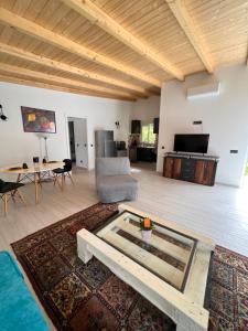 Carvoeiro B&B and SPA في كارفويرو: غرفة معيشة مع طاولة زجاجية وأريكة