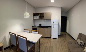 uma cozinha e sala de jantar com uma mesa e um frigorífico em Studio em Florianópolis