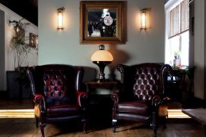 two leather chairs and a lamp in a room at The Southern Belle in Brighton & Hove