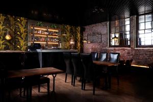 a bar with wooden tables and chairs in a room at The Southern Belle in Brighton & Hove