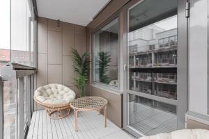 einen kleinen Balkon mit einem Stuhl und einem Stuhl in der Unterkunft Beautiful and cozy Studio in a New building in Stockholm