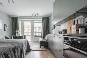 ein Schlafzimmer mit einem Bett, eine Küche und ein Wohnzimmer in der Unterkunft Beautiful and cozy Studio in a New building in Stockholm