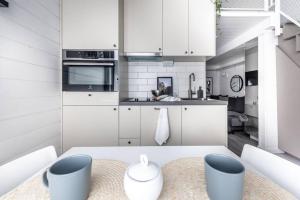 cocina con armarios blancos y mesa en Discover Gothenburg from equpped Studio, en Gotemburgo