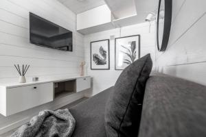 Habitación con cama, TV y sofá. en Discover Gothenburg from equpped Studio, en Gotemburgo