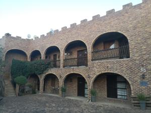 a brick building with arches and a balcony at Bastille de Blignaut B&B in Edenvale