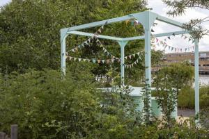 a blue arch with flags and a fountain in a garden at Explore Gothenburg from modern apt for 4 guest in Gothenburg