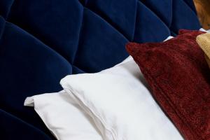 a red pillow sitting on top of a blue couch at The Southern Belle in Brighton & Hove