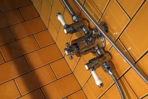 a view of a bathroomaucet and tiles on a wall at The Southern Belle in Brighton & Hove +37 photos