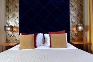 a bedroom with a large bed with a blue headboard at The Southern Belle in Brighton & Hove